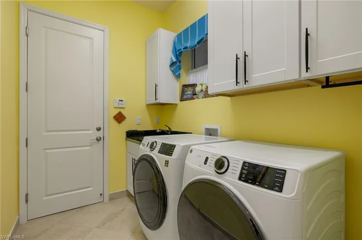 Cheery laundry room has laundry sink plus cabinetry! Connects to the 3 car garage.