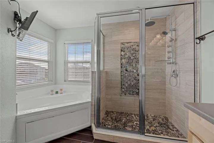 Master bath with shower with separate bathtub and tile floors