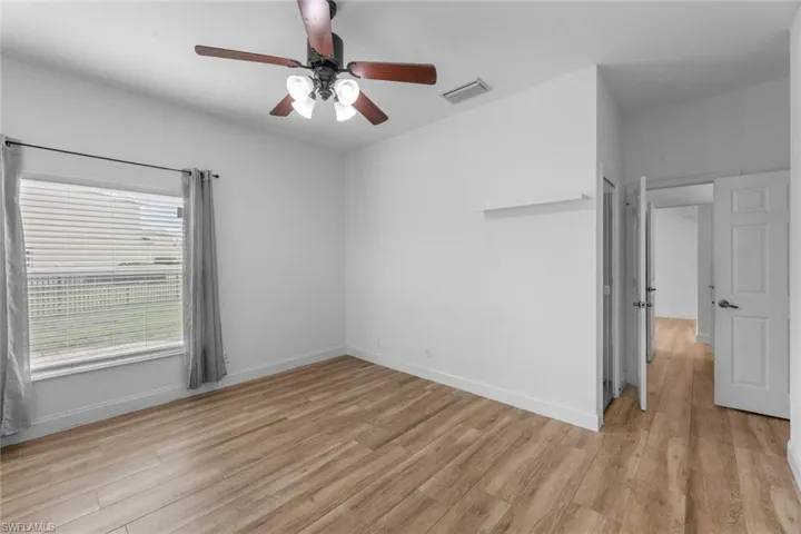 Empty room with light hardwood / wood-style floors and ceiling fan