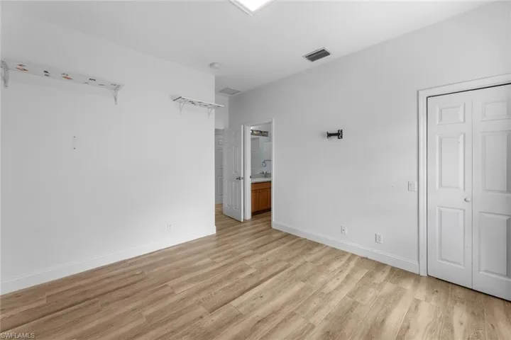 Unfurnished bedroom with light hardwood / wood-style floors, sink, and ensuite bathroom