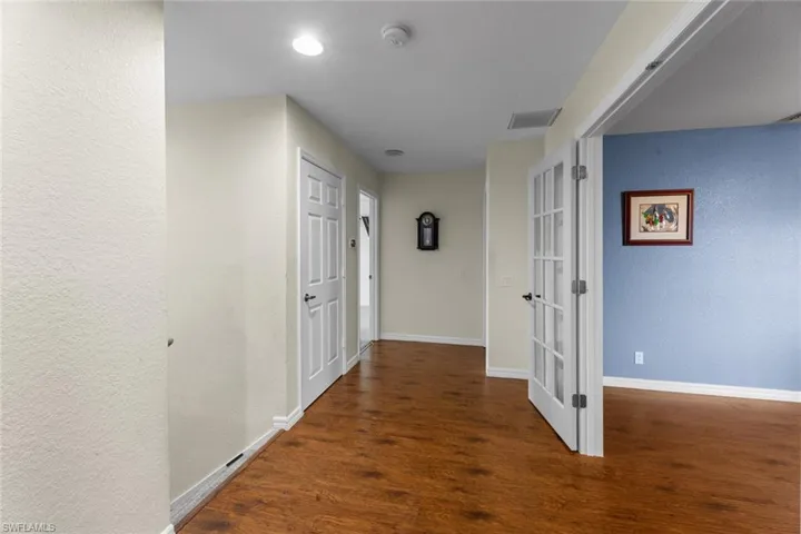 Corridor with dark hardwood / wood-style floors