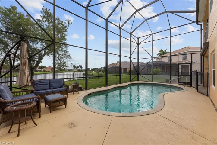 View of swimming pool featuring a patio, a lanai, and a yard