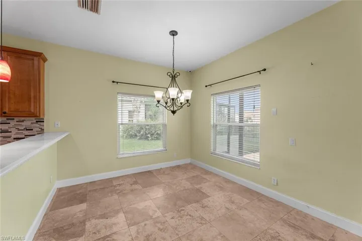 Unfurnished dining area featuring a notable chandelier and light tile floors
