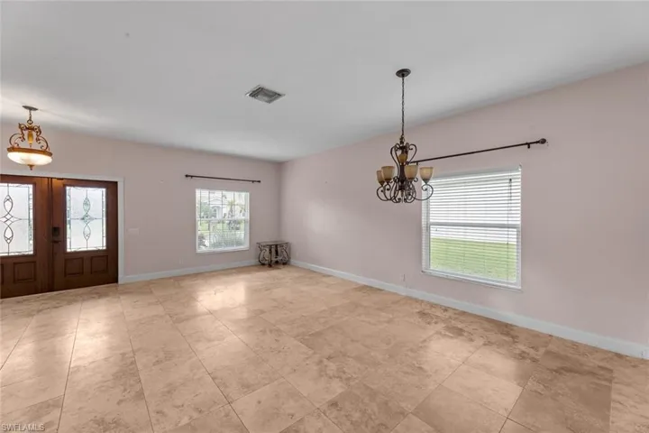 Tiled foyer entrance with an inviting chandelier