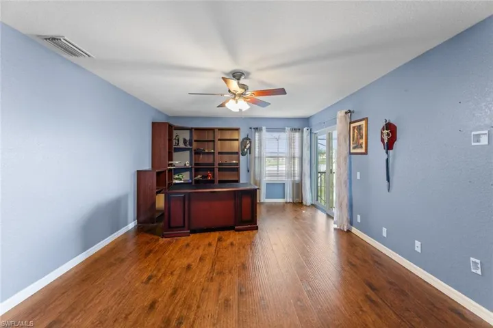 Unfurnished office featuring dark hardwood / wood-style floors and ceiling fan