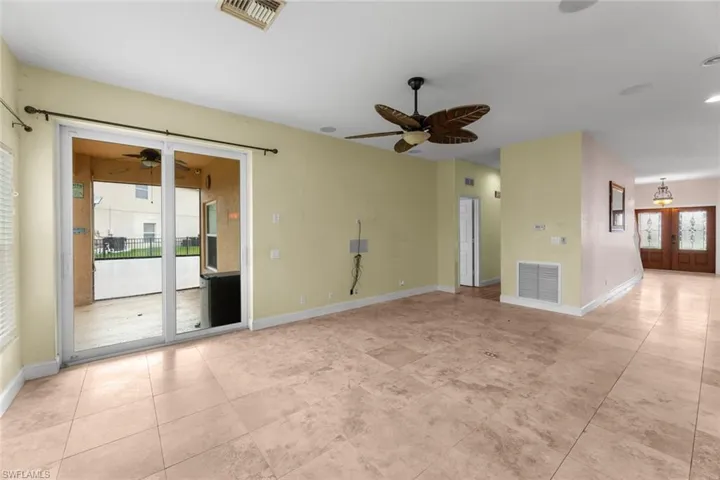 Unfurnished room featuring french doors, ceiling fan, and light tile floors