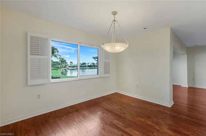 Unfurnished dining area featuring a water view and hardwood / wood-style floors