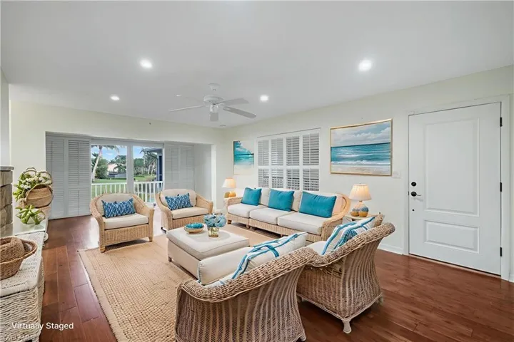 Living room with dark wood-type flooring, recessed lighting, and a ceiling fan