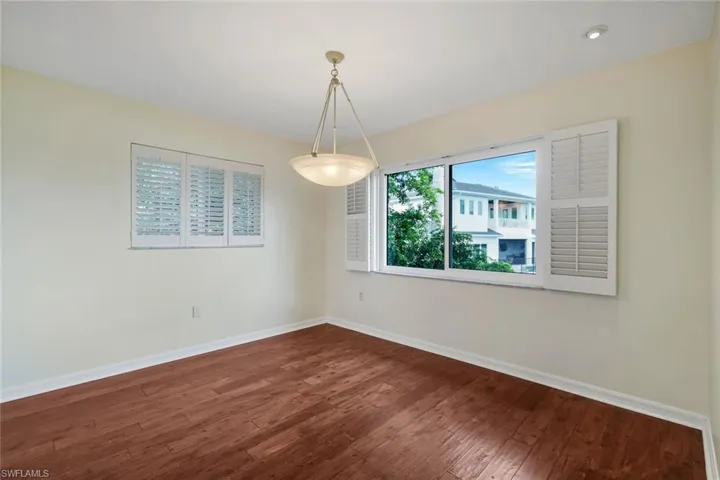 Empty room with dark wood-style floors and baseboards