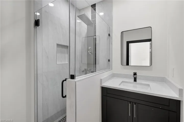 Full bathroom with vanity and a marble finish shower