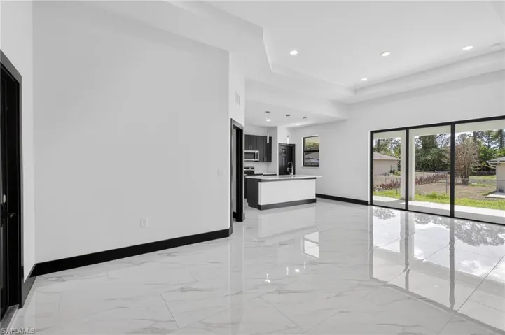 Empty room featuring light marble finish flooring, recessed lighting, and a raised ceiling