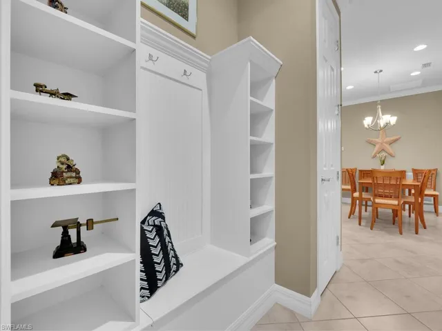 Spacious closet with a chandelier and light tile patterned floors