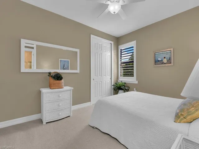 Carpeted bedroom featuring a closet and ceiling fan