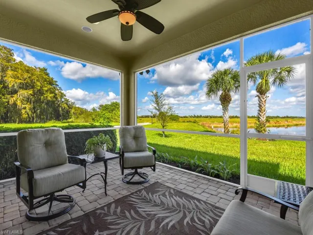 Sunroom with a wealth of natural light, a water view, and ceiling fan