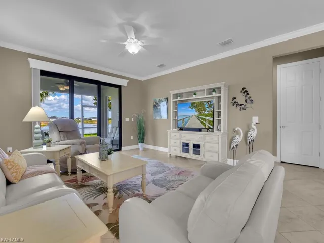 Tiled living room with crown molding and ceiling fan