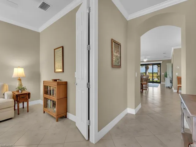 Hallway featuring ornamental molding and light tile patterned floors