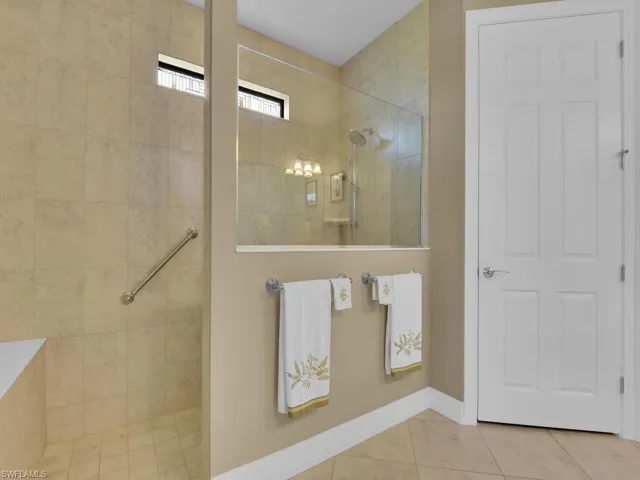 Bathroom with a tile shower and tile patterned flooring