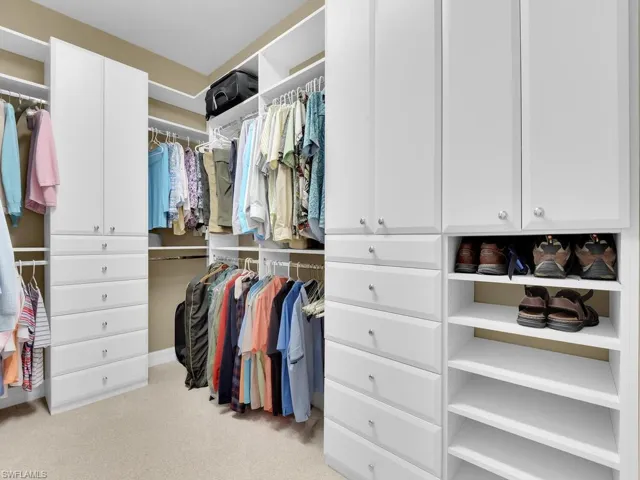 Walk in closet with light carpet