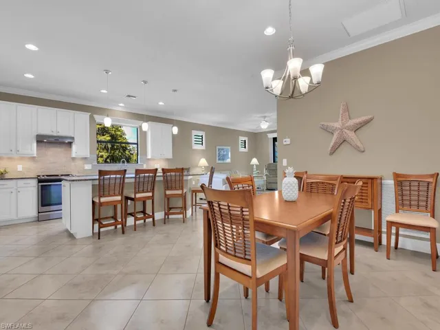 Dining space featuring ornamental molding, a chandelier, and light tile patterned floors