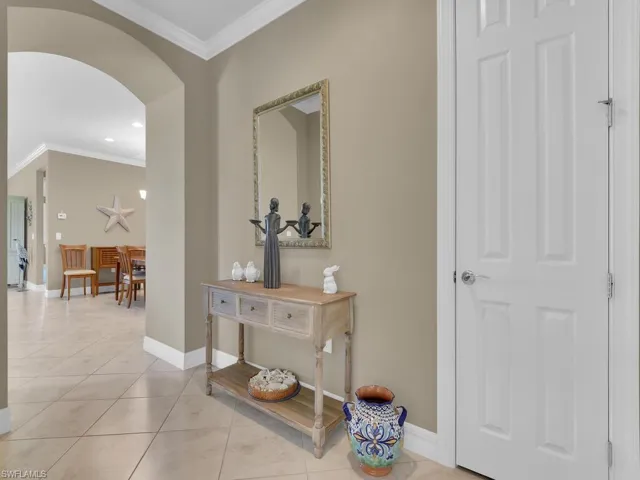 Hallway featuring crown molding and light tile patterned floors