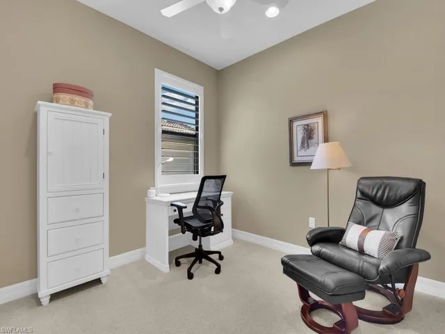 Carpeted office space featuring ceiling fan