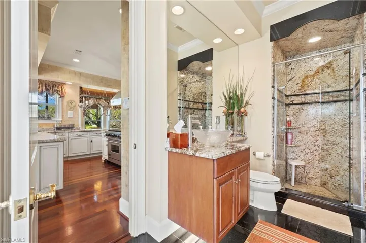 Bathroom with vanity, a stall shower, and crown molding