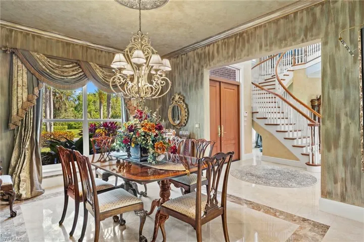 Dining room with a chandelier, stairway, marble finish floor, and ornamental molding