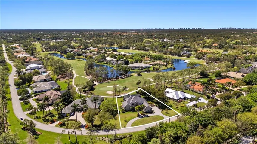 Birds eye view of property with golf course view, a water view, and a residential view