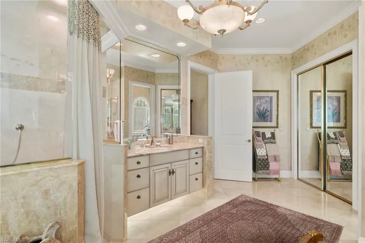 Bathroom with curtained shower, crown molding, baseboards, a chandelier, and vanity