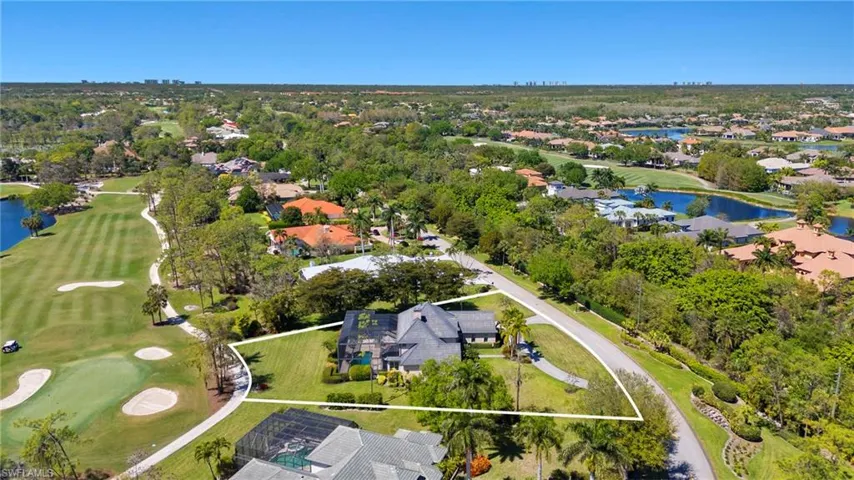 Birds eye view of property with view of golf course and a water view