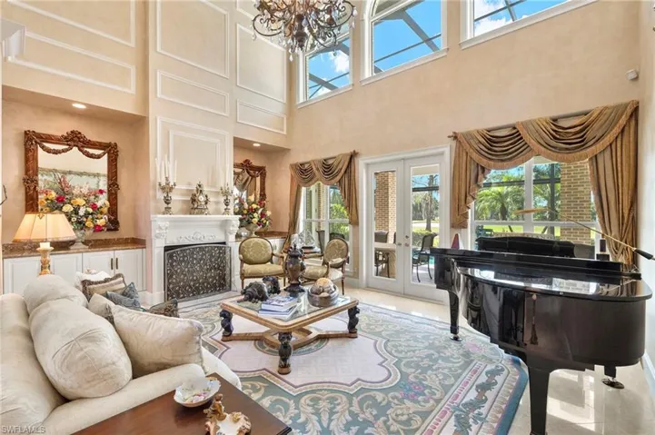 Living area featuring a wealth of natural light, french doors, an inviting chandelier, and a fireplace