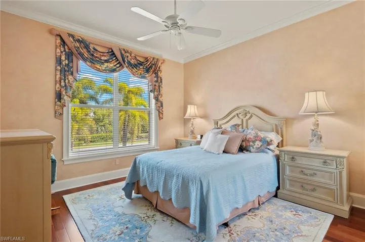Bedroom with baseboards, a ceiling fan, wood finished floors, and crown molding