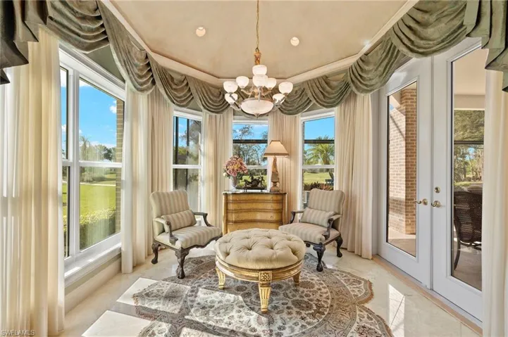 Sitting room with a notable chandelier and marble finish floor