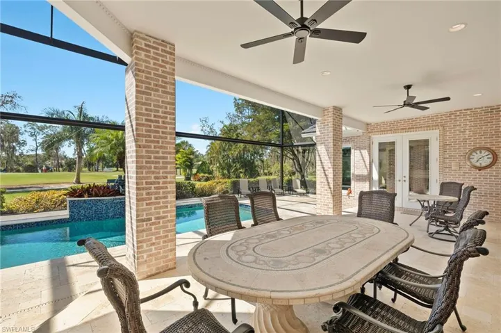 View of patio featuring a lanai, an outdoor pool, french doors, and ceiling fan