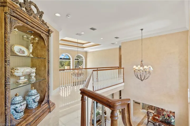 Hallway featuring visible vents, an upstairs landing, a chandelier, and crown molding