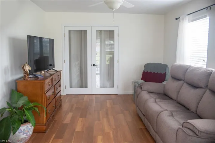 Living room featuring ceiling fan, french doors, and hardwood / wood-style flooring