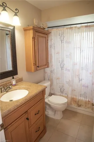 Bathroom featuring tile patterned flooring, toilet, and vanity