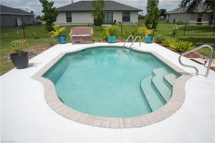 View of pool featuring a lawn