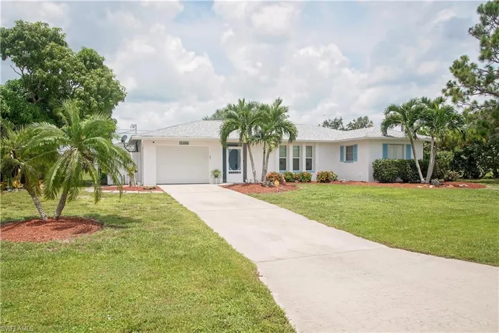 Ranch-style house with a garage and a front lawn