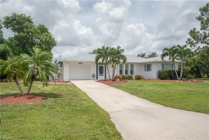 Ranch-style house featuring a garage and a front yard