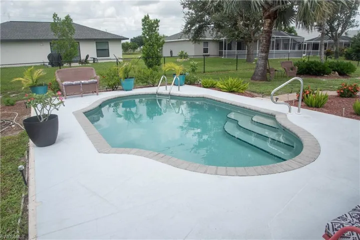 View of swimming pool featuring a patio and a lawn