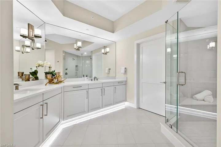 Master Suite Bathroom with a stall shower, double vanity, and light tile patterned floors