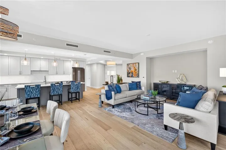 Living room, dining room and kitchen featuring coastal contemporary decor , recessed lighting and light wood-style floors
