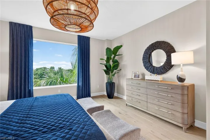 Master Suite with large window gives views of tropical palm trees and florida mangroves