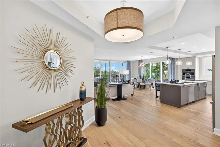Large inviting entryway with a tray ceiling and light wood-style flooring