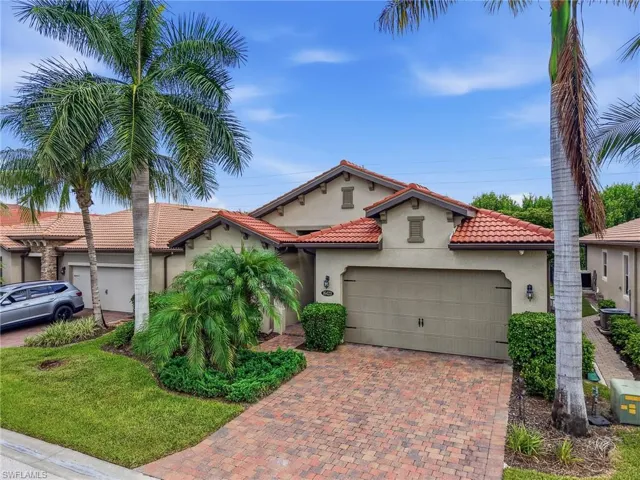 Mediterranean-inspired exterior featuring a terracotta tile roof, stucco finish, and an integrated two-car garage