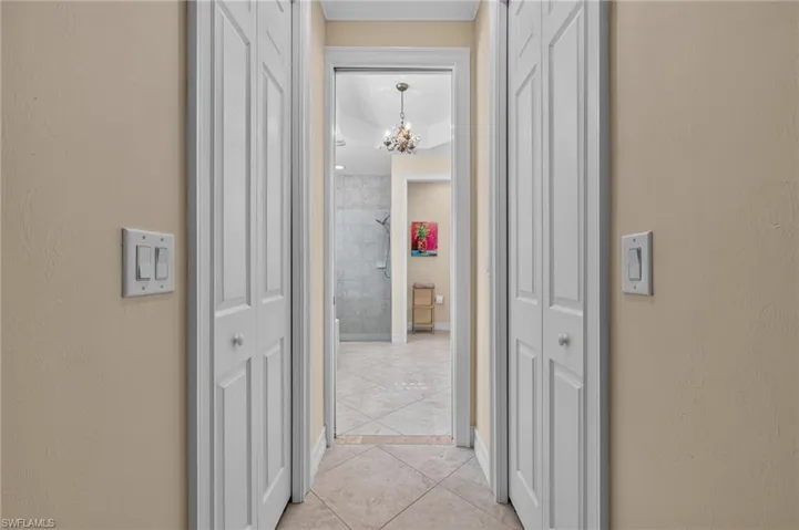 Hallway featuring neutral wall paint, white bi-fold closet doors, and recessed lighting