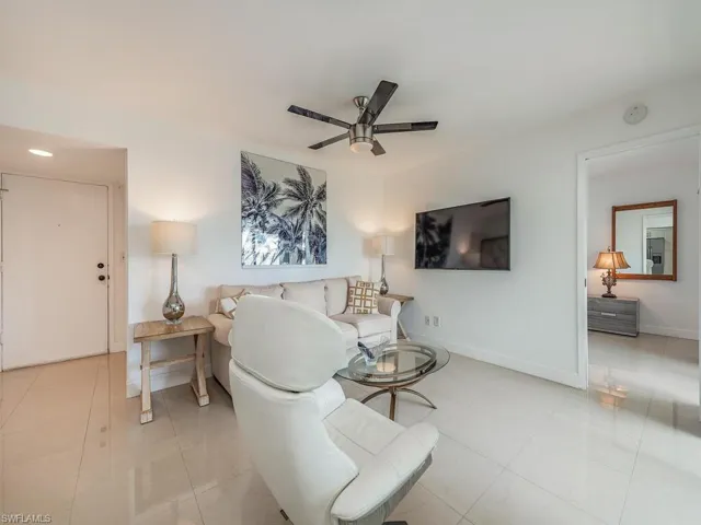 Living area featuring ceiling fan, light tile patterned floors, and baseboards