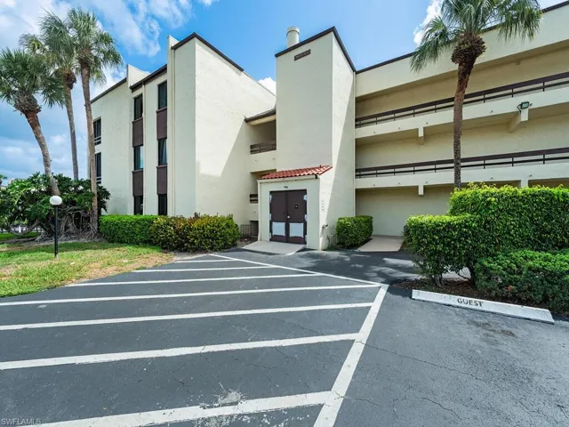 View of building exterior featuring uncovered parking