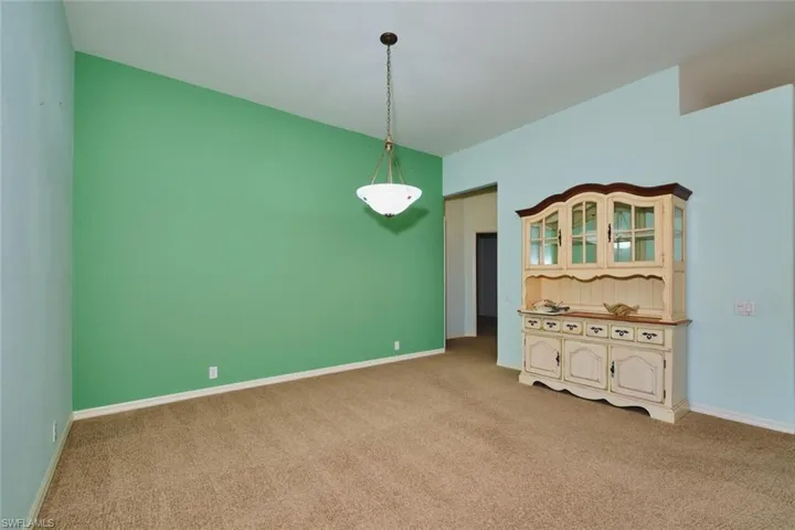 Empty room featuring light carpet and baseboards